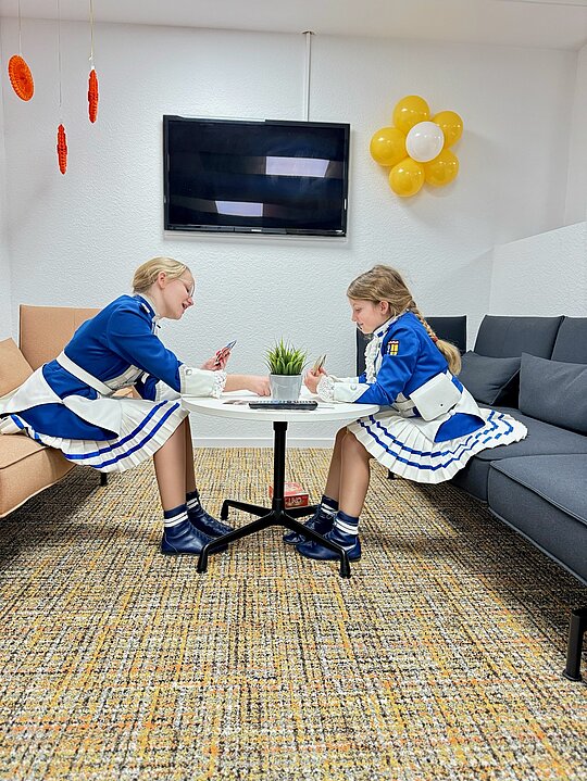 Zwei Mädchen der Kinderprinzengarde sitzen an einem Tisch in einem Mönchengladbacher Büro.