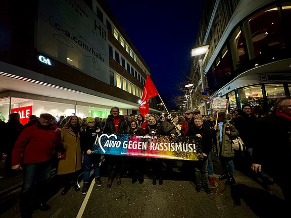 Eine Gruppe von Menschen geht mit einem Transparent mit der Aufschrift "AWO gegen Rassismus" durch eine Straße in Mönchengladbach.