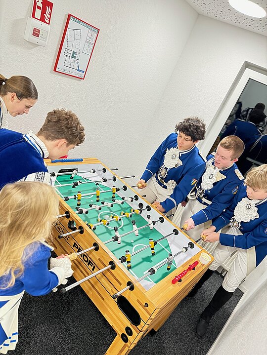 Eine Gruppe Kinder spielt in einem Büro in Mönchengladbach eine Partie Tischfußball.