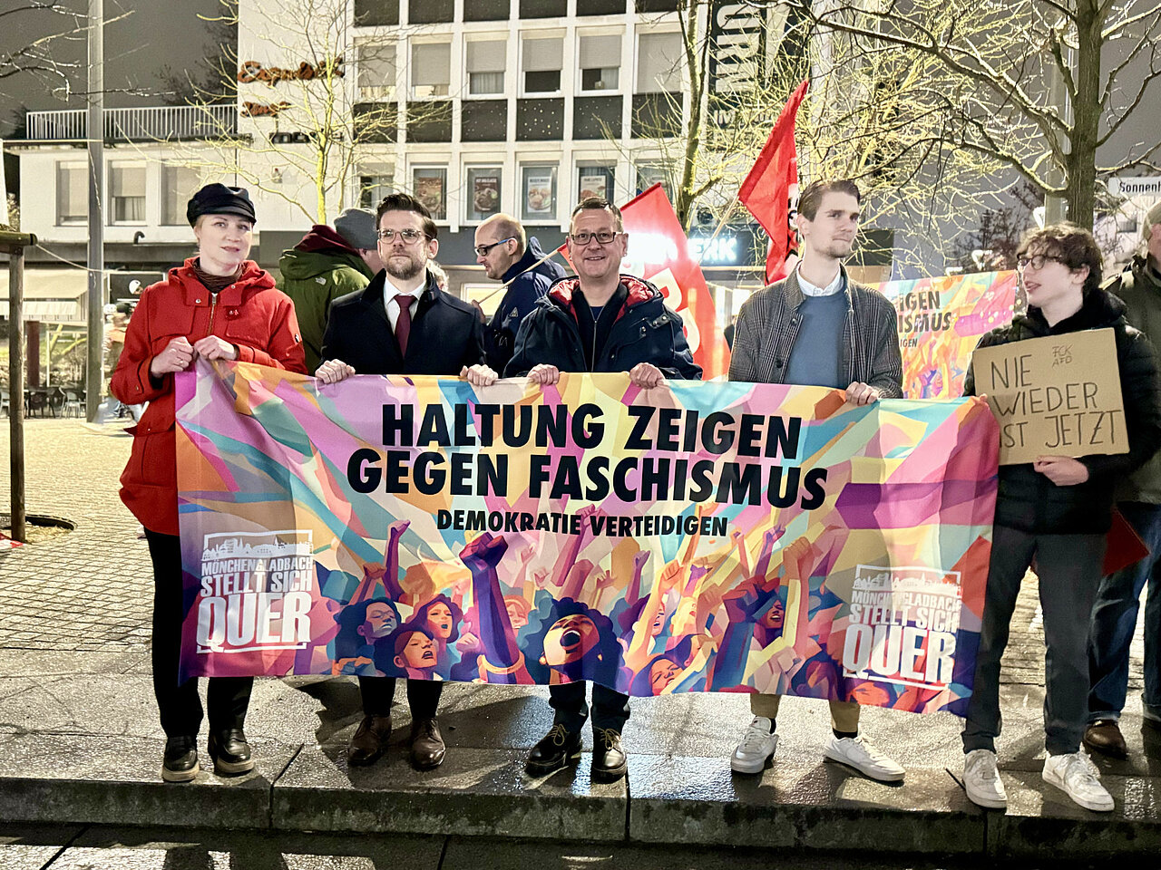 Eine Gruppe von Menschen hält einem Transparent hoch mit der Aufschrift "Haltung zeigen gegen Faschismus".