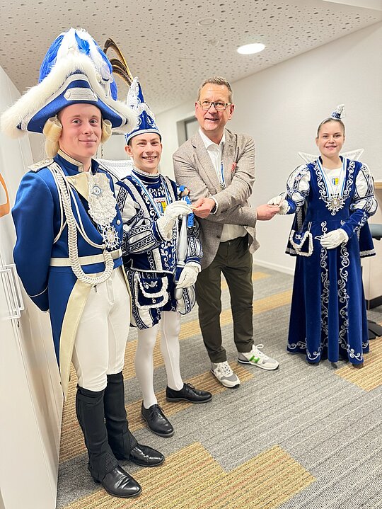 Eine Gruppe kostümierter Menschen, darunter das Kinderprinzenpaar, steht nebeneinander in der Hofburg.